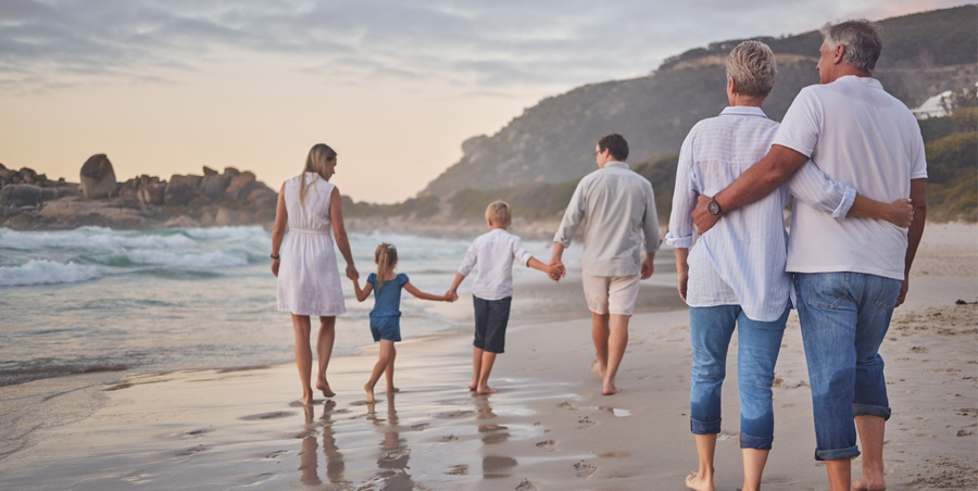 Extended family walking on beach.